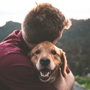 Man hugging dog; animal healthcare trends.